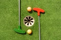 Mini-golf clubs and balls of different colors laid on artificial grass. Royalty Free Stock Photo