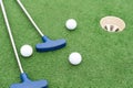 Mini-golf clubs and balls of different colors laid on artificial grass Royalty Free Stock Photo