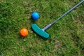 Mini golf equipment, balls and a club on the grass, high angle view from above, copy space Royalty Free Stock Photo
