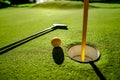 Mini Golf yellow ball with a bat near the hole at sunset Royalty Free Stock Photo