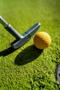 Mini Golf yellow ball with a bat near the hole at sunset Royalty Free Stock Photo