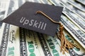 Mini graduation cap with Upskill text on money