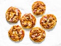 Mini ham, tomato sauce, mozzarella pizza on a light background, top view. Delicious breakfast, snack, tapas Royalty Free Stock Photo