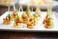 mini hot dogs with relish on a platter for a party