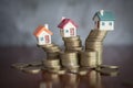 Mini house on stack of coins, Concept of Investment property, Investment risk and uncertainty in the real estate housing market Royalty Free Stock Photo