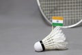 Mini India flag stick on the white shuttlecock on the grey background and out focus badminton racket