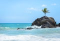 Mini island with a single coconut tree surrounded by sea water and some rock formations in a paradisiacal scenery, very beautiful