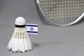 Mini Israel flag stick on the white shuttlecock on the grey background and out focus badminton racket