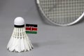 Mini Kenya flag stick on the white shuttlecock on the grey background and out focus badminton racket