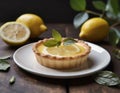 Mini lemon tart, decorated with a slice of lemon, on a dark wooden table