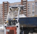 The mini-loader removes snow, clearing the city .Cleaning of the territory by public utilities in winter Royalty Free Stock Photo