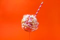 Mini marshmallows in a glass on a bright orange background. Multi-colored marshmallows in a glass Royalty Free Stock Photo