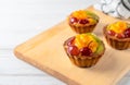 Mini mixed fruit tarts with orange cherry and kiwi on wooden plate Royalty Free Stock Photo