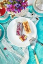 Mini Mousse Cake with chocolate, covered with blue spray and decorated with pink roses with cups of tea Royalty Free Stock Photo