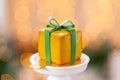Mini mousse pastry dessert with yellow glazed. garland lamps bokeh background. In the form of gift box, ribbons of