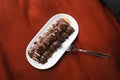 Mini pancakes with banana, poured with chocolate in a plate in bed, top view. Royalty Free Stock Photo