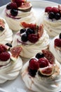 Mini Pavlova meringue cakes decorated with berries and figs Royalty Free Stock Photo