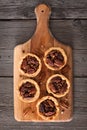 Pecan pie tarts on a wooden paddle board