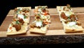 Mini pizza appetizers on wooden cutting board