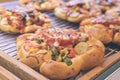 Mini pizzas with cheese, tomato, green beans, corn and sausages in the shoppin mall, small italian bakery. Tropical Royalty Free Stock Photo