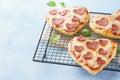 Mini pizzas with heart shaped pepperoni, mozzarella and basil