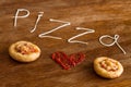 Mini pizzas with sausage and cheese on wood table Royalty Free Stock Photo