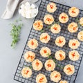 Mini quiche muffins with feta cheese, fried onion, thyme and red bell pepper, on cooling rack, top view, square format