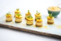 mini raw mango cheesecakes in rows on tray