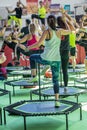 Mini Rebounder Workout - Girls doing Fitness Exercise in Class at Gym with Music and Teacher on Stage Royalty Free Stock Photo