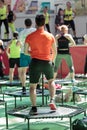 Mini Rebounder Workout - People doing Fitness Exercise in Class at Gym with Music and Teacher on Stage