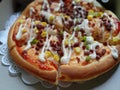 Mini round pizza topped with bacon, sweet corn, mayonnaise and tomato sauce.
