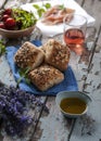 Mini rustic bread with lavand flower on the side, olive oil, rose wine, cherry tomatoes and prosciuto