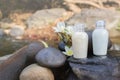 Mini set of bubble bath shower gel liquid with flowers and pebble on waterfall rock Royalty Free Stock Photo