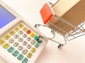 Mini shopping cart with a box and calculator isolated on a pink surface Royalty Free Stock Photo