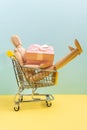 Mini shopping cart buying gifts with wooden mannequin. advertisement for gift from all or composition concept. Vertical Royalty Free Stock Photo