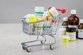 Mini shopping cart full of homeopathic remedies. Concept of buying homeopathic drugs.