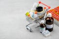 Mini shopping cart full of homeopathic remedies and first aid kit with different homeopathic preparation.
