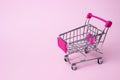 Mini shopping cart retail theme Little shopping cart on a pink paper background Royalty Free Stock Photo