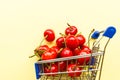 Mini shopping grocery cart full of fresh cherries Fresh berries on yellow background. Healthy summer food concept Royalty Free Stock Photo