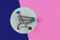 Mini shopping trolley cart on light green, pink and blue navy background. Online shopping, buy, sale, discount concept Royalty Free Stock Photo