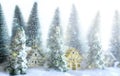 Mini snowy Christmas trees with houses in the forest. Bokeh lights background Royalty Free Stock Photo