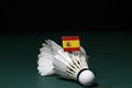 Mini Spain flag stick on the used shuttlecocks on green floor of Badminton court