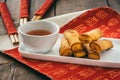 Mini spring rolls with sweet spicy dip on a white plate on a red chinese place mat Royalty Free Stock Photo