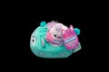 Mini-squishmallow and vehicle made of child safe materials and green pink and white in colour