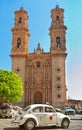 Mini taxi against the Cathedral of Taxco, Mexico.