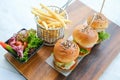 mini three burgers served with french fries on wooden tray
