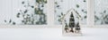 Mini tiny Christmas greenhouse in white room. Christmas terrarium with fir trees, moss, lights, mini houses, berries. Shop Glass