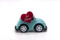 Mini toy car carrying red heart shape with text Just Married. Newly wed couple concept. Royalty Free Stock Photo