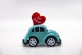 Mini toy car carrying red heart shape with text Just Married. Newly wed couple concept. Royalty Free Stock Photo