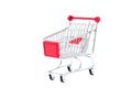 Mini toy metal shopping trolley cart with red handle and four black wheels isolated on white background. Supermarket shopping, Royalty Free Stock Photo